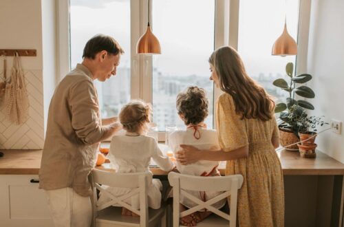 Still feeling overwhelmed in the morning? Try this evening routine to make mornings smoother. 8 A family enjoying breakfast together in a warm sunlit kitchen, fostering togetherness.